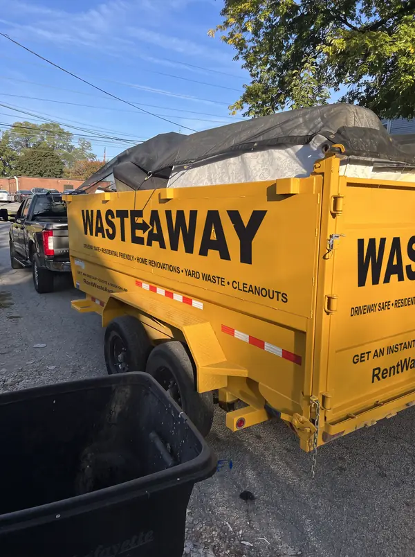 Waste Away dumpster tarped and parked in an alley