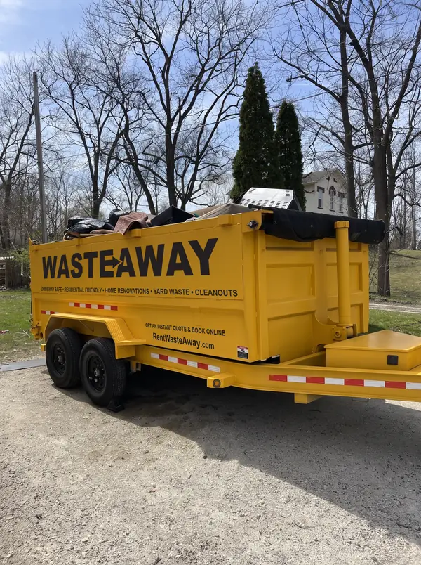 Waste Away dumpster loaded with furniture and household junk